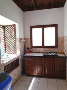 a kitchen with a stove and two windows at Condominio Villa Hermosa in Playa Hermosa