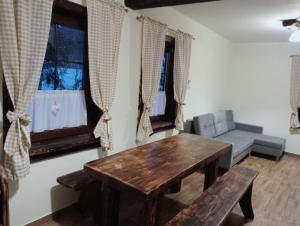 a living room with a wooden table and a couch at Zagroda Miodowa agroturystyka w Bieszczadach in Komańcza +9 photos