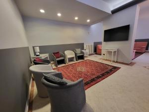 a living room with chairs and a flat screen tv at Hotel Giovanna in Montecatini Terme