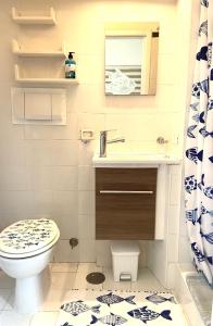 bagno con servizi igienici, lavandino e specchio di Pino Marino a San Felice Circeo