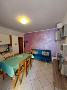 une cuisine avec une table et des chaises dans une pièce dans l'établissement Appartamento al faro, à Caorle