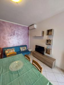 une salle à manger avec une table verte et un canapé dans l'établissement Appartamento al faro, à Caorle