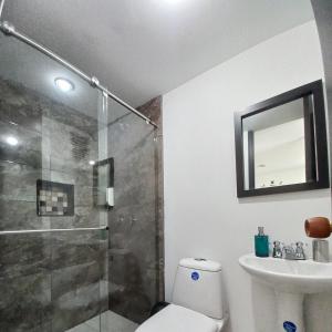 een badkamer met een douche, een toilet en een wastafel bij aparta hotel turístico a 2 km parque del café in Montenegro