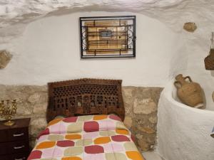 Casa rural El Parral في Bedmar: غرفة نوم مع سرير ونافذة على الحائط