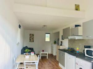 kuchnia ze stołem oraz kuchnia z kuchenką mikrofalową w obiekcie Loue Studio dans une villa avec piscine terrasse w mieście Saint-Théodorit +4 zdjęcia
