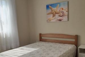 a bedroom with a bed and a picture on the wall at Férias Perfeitas, Praia e Piscina in Itapoa