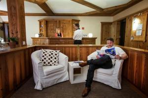 a man sitting in chairs in a barber shop at T3 Gasthof Spullersee in Wald am Arlberg