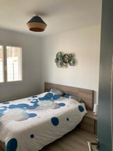 - une chambre avec un grand lit orné de fleurs bleues dans l'établissement La Villa Omaha YourHostHelper, à Marcheprime