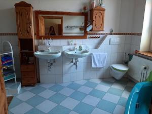 a bathroom with two sinks and a toilet at Ferienwohnung Bioland-Hof Wilkens in Visselhövede +10 photos