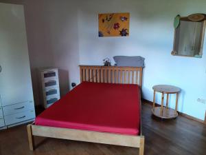 1 cama con colchón rojo en una habitación en Ferienwohnung Bioland-Hof Wilkens en Visselhövede