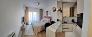 ein kleines Schlafzimmer mit einem Bett und einer Küche in der Unterkunft Studio apartment Lora Lux in Sarajevo