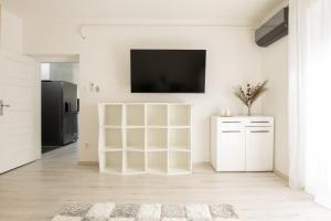 uma sala de estar branca com uma televisão na parede em Smart Square with free parking em Debrecen