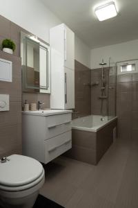 een badkamer met een toilet, een wastafel en een bad bij Smart Square with free parking in Debrecen