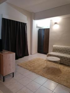 a living room with a couch and a coffee table at Hotel Marko in Loutraki