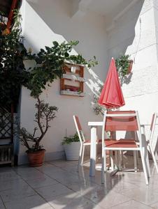 巴勒摩的住宿－Dietro il massimo，一张桌子和两把椅子以及一把红色雨伞