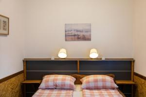 a bedroom with two beds and two lights on the wall at Apartmani Papeš in Krapina