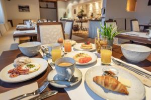 una mesa de madera con platos de comida. en Pension Edelweiss, en Sölden