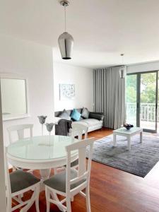 uma sala de estar branca com uma mesa e cadeiras em Ocean Pearl Apartment X no Funchal