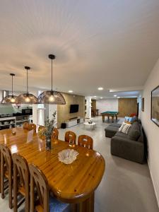 ein Esszimmer und ein Wohnzimmer mit einem Holztisch in der Unterkunft Santiago 2 in Castelo do Neiva