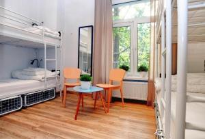 a room with two bunk beds and a table and chairs at Warsaw Hostel Centrum Private Rooms & Dorms in Warsaw