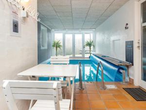 Pokój z basenem, stołem i krzesłami w obiekcie 10 person holiday home in Bl vand w mieście Blåvand