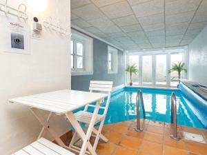 basen ze stołem i krzesłami w pokoju w obiekcie 10 person holiday home in Bl vand w mieście Blåvand