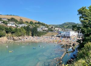 a group of people on a beach in the water at Channel Vista Guest House in Combe Martin