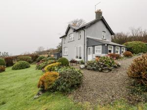 a white house with a garden in front of it at Sibrwd Y Mor in Harlech