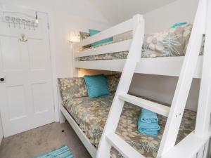 a bunk bed in a tiny room with a couch on the bottom bunk at Sibrwd Y Mor in Harlech +48 photos