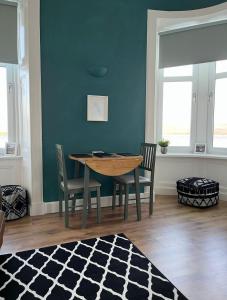 a dining room with a wooden table and chairs at Beautiful Upper Apartment/Stunning Sea Views, Isle of Bute in Port Bannatyne