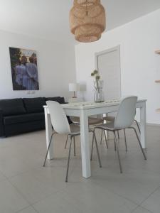 een witte tafel en stoelen in de woonkamer bij Laguna house in Càbras