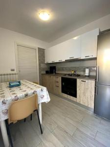 a kitchen with a table and a stainless steel refrigerator at Domus Sici in Pompei