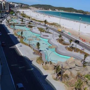 eine Luftansicht auf einen Strand mit einem Wasserpark in der Unterkunft Meu Aconchego in Cabo Frio