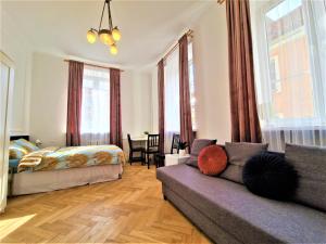 ein Wohnzimmer mit einem Sofa und einem Bett in der Unterkunft J&W Apartments Świętojańska Rooms in Warschau