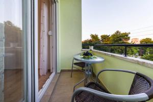 a balcony with a table and chairs and a window at Apartment Sara in Zadar