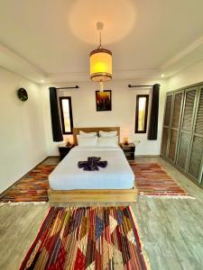 Dar Ayman Essaouira في الصويرة: غرفة نوم بسرير وسجادة كبيرة