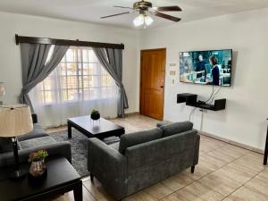 a living room with two couches and a flat screen tv at Apartamentos Villas del Sol in San Pedro Sula