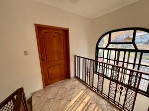 a staircase with a wooden door and a window at Apartamentos Villas del Sol in San Pedro Sula