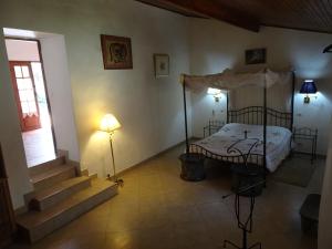 Villa Denise - île de Gorée في غوري: غرفة نوم بسرير مظلة ودرج