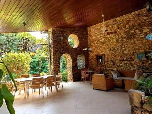 Villa Denise - île de Gorée في غوري: فناء مع طاولة وكراسي وجدار من الطوب