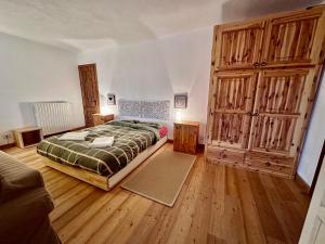 a bedroom with a large bed and wooden floors at La Baita di BessenHaut 