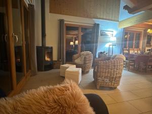 a dog sitting in a chair in a living room with a fireplace at Chalet familial in Chamoson