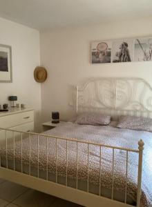 a bedroom with a white bed with a metal headboard at L'instant d'un séjour in Le Guâ
