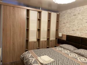 um quarto com uma cama e algumas prateleiras de madeira em Brand New Valera Luxury Studio em Varna City