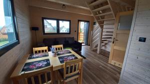 a tiny house with a table and chairs and a couch at Domek Wakacyjny Pod Gruszą in Lubin