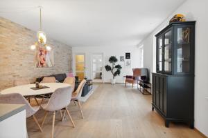 uma sala de jantar e sala de estar com uma parede de tijolos em Central 3-bedroom apartment with a big terrace and fitness room em Aalborg