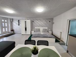 een slaapkamer met een bed en een tafel en stoelen bij Apartament DADA in Sighişoara