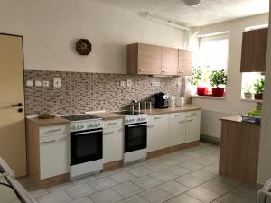 a kitchen with white counters and white appliances at Penzion Pod Hamižnou in Hartmanice