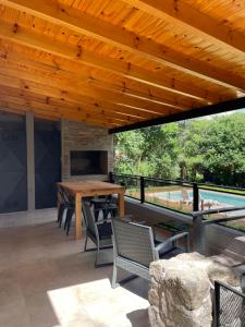 an outdoor patio with a wooden table and chairs at La Franca Aparts in Villa General Belgrano