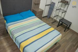 a bedroom with a bed with blue and yellow sheets at Hermosa familiar pool ,cerca de playa by G P S rentas in Mazatlán +26 photos